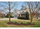 Two-story home featuring stone accents, a covered porch, and a well-manicured lawn with daffodils at 3609 Kilgo Dr, Durham, NC 27705