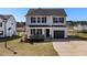 Charming two-story home featuring gray siding, a one-car garage, and a welcoming front porch with an American flag at 38 Winter Red Way, Benson, NC 27504