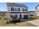Charming two-story home featuring gray siding, a one-car garage, and a welcoming front porch with an American flag at 38 Winter Red Way, Benson, NC 27504