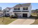 Charming two-story home featuring gray siding, a one-car garage, and a welcoming front porch with an American flag at 38 Winter Red Way, Benson, NC 27504
