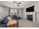 Inviting living room featuring a stone fireplace, a ceiling fan, and comfortable blue seating at 38 Winter Red Way, Benson, NC 27504