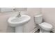 Bright bathroom featuring a pedestal sink, modern toilet, and neutral color palette at 42 Sweet Meadow Rd, Angier, NC 27501