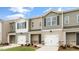 View of new townhomes showing exteriors in neutral colors, garages and well manicured lawn at 42 Sweet Meadow Rd, Angier, NC 27501