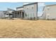 Gray home's backyard features a spacious lawn leading up to a screened-in porch, under a clear sky at 4513 Bridle Run Dr, Raleigh, NC 27606