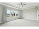 Bedroom featuring large windows, ceiling fan, and neutral colored carpet at 4513 Bridle Run Dr, Raleigh, NC 27606