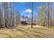 Expansive backyard with a view of the house, featuring a deck, screened porch, and surrounded by mature trees at 484 Galaxy Dr, Garner, NC 27529