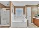 Bathroom featuring a large soaking tub with tile surround and a separate glass door shower at 484 Galaxy Dr, Garner, NC 27529