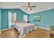 Bright bedroom with turquoise walls, wood floors, vaulted ceiling, and natural light from the windows at 484 Galaxy Dr, Garner, NC 27529