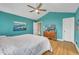 Well-lit bedroom with vibrant turquoise walls, wood floors, and a comfortable, inviting atmosphere at 484 Galaxy Dr, Garner, NC 27529
