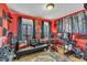 Vibrant red bonus room with a black futon, gaming setup, and natural light at 484 Galaxy Dr, Garner, NC 27529