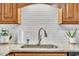 Detailed view of the kitchen sink with granite countertops and subway tile backsplash at 484 Galaxy Dr, Garner, NC 27529