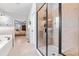 Contemporary bathroom featuring a tiled shower with glass door, and a soaking tub with bronze fixtures at 50 Lockamy Ln, Youngsville, NC 27596