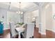 Charming dining room featuring a modern chandelier, a light blue accent wall, and plantation shutters at 50 Lockamy Ln, Youngsville, NC 27596