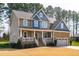 Charming two-story home featuring a covered front porch, a side-entry garage, and mature trees at 50 Lockamy Ln, Youngsville, NC 27596