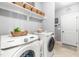 Practical laundry room with modern washer and dryer units, storage space, and tiled flooring at 50 Lockamy Ln, Youngsville, NC 27596