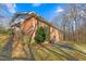 Rear exterior view of a brick home showing backyard access and well-maintained landscaping at 501 Orange High School Rd, Hillsborough, NC 27278
