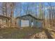 Exterior view of a blue garage with a white door, surrounded by mature trees at 501 Orange High School Rd, Hillsborough, NC 27278