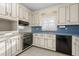 Classic kitchen with white cabinets, blue countertops, and black dishwasher at 501 Orange High School Rd, Hillsborough, NC 27278