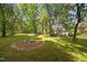 An in-ground fire pit surrounded by trees offers a great place to unwind in the backyard at 513 N Nash St, Hillsborough, NC 27278