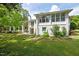 Backyard view of home with open carport and many windows with large well manicured yard at 513 N Nash St, Hillsborough, NC 27278