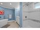 Modern primary bath featuring a walk-in shower, soaking tub, vanity, and blue walls at 513 N Nash St, Hillsborough, NC 27278