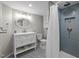 Modern bathroom featuring patterned tile floors, white vanity, and glass enclosed shower with blue tiling at 513 N Nash St, Hillsborough, NC 27278