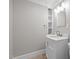 Bathroom with a stylish white vanity, storage shelf, and neutral color scheme at 513 N Nash St, Hillsborough, NC 27278