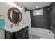 Sleek bathroom with black vanity, round mirror, and modern black and white tile at 513 N Nash St, Hillsborough, NC 27278