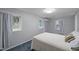 Bright bedroom featuring three windows, light grey walls, and blue carpeting at 513 N Nash St, Hillsborough, NC 27278