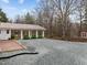 Wide driveway leads to a white brick house with a covered entrance, featuring a mix of textures and plantings at 513 N Nash St, Hillsborough, NC 27278