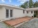 White brick exterior detail showcasing French doors and adjacent patio, accentuating outdoor access at 513 N Nash St, Hillsborough, NC 27278