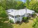 Aerial view of the home showcasing its updated metal roof, white brick, and lush landscaping at 513 N Nash St, Hillsborough, NC 27278