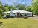 Charming single-story home with a white exterior, red front door, lush lawn, and mature landscaping at 513 N Nash St, Hillsborough, NC 27278