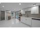 Bright kitchen with white cabinets, stainless steel sink, and open shelving, sliding glass doors to yard at 513 N Nash St, Hillsborough, NC 27278