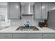Close up of a kitchen featuring a gas stovetop, stainless steel range hood and a modern countertop at 513 N Nash St, Hillsborough, NC 27278