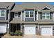 Two-story townhouse with stone accents, a white garage door, and gray siding under a sunny sky at 519 Flat Ford Rd, Hillsborough, NC 27278