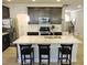 Bright kitchen with a white countertop island features stainless steel appliances and barstool seating at 519 Flat Ford Rd, Hillsborough, NC 27278