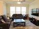 Comfortable living room featuring a ceiling fan, large windows, and cozy furnishings at 519 Flat Ford Rd, Hillsborough, NC 27278