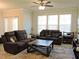 Living room featuring a ceiling fan, three windows, and comfortable furnishings at 519 Flat Ford Rd, Hillsborough, NC 27278