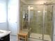 Modern bathroom with a glass enclosed shower, neutral tiles, and a wood bench for comfort at 519 Flat Ford Rd, Hillsborough, NC 27278