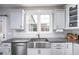 Well-lit kitchen featuring white cabinets, granite countertops, stainless steel sink, and modern appliances at 52 N Rosebank Dr, Chapel Hill, NC 27516