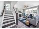 Cozy living room with fireplace, ceiling fan, and stairs leading to upper level at 52 N Rosebank Dr, Chapel Hill, NC 27516