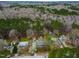 Expansive aerial view showcasing homes nestled within a lush, wooded neighborhood, under a cloudy sky at 5216 Passenger Pl, Raleigh, NC 27603