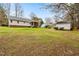 Expansive backyard with a view of the home's exterior and wooded surroundings at 5216 Passenger Pl, Raleigh, NC 27603