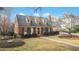 Quaint brick home featuring dormer windows, lush lawn, and a winding walkway at 527 N Main St, Wake Forest, NC 27587