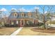 Charming brick home featuring dormer windows, manicured landscaping, and mature trees at 527 N Main St, Wake Forest, NC 27587