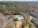 Aerial view showcases the community pool, playground, parking, landscaping and surrounding forest at 5421 Vista View Ct, Raleigh, NC 27612