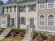 Inviting townhome featuring beige siding, dark shutters, and a well-maintained front yard at 5421 Vista View Ct, Raleigh, NC 27612