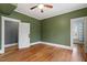 A bedroom featuring hardwood floors, green walls and white trim and door frames at 5505 Farrington Rd, Chapel Hill, NC 27517