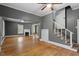 Bright living room with hardwood floors, fireplace, ceiling fan, and staircase at 5505 Farrington Rd, Chapel Hill, NC 27517